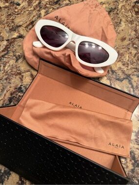 Alaïa White Oval Sunglasses with Dark Lenses